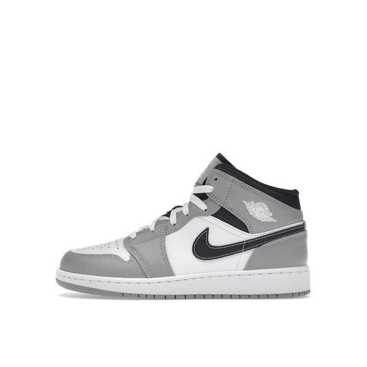 Jordan 1 Mid sneakers (GS), side view, model 554725-078, in light smoke grey with black and white accents.