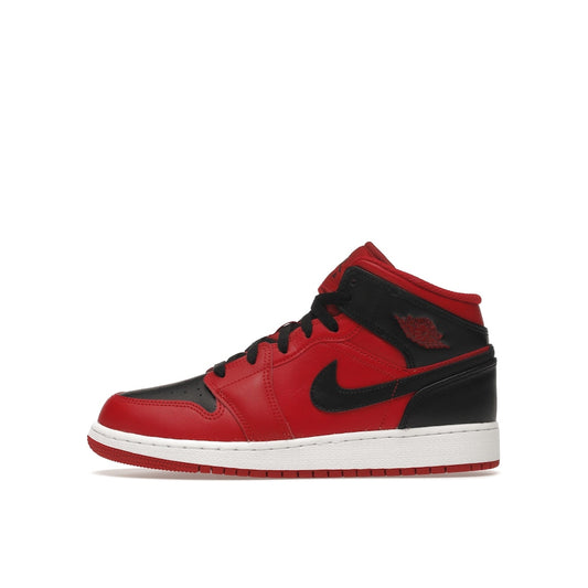 Jordan 1 Mid GS sneakers, side view, in red with black accents and white midsole.
