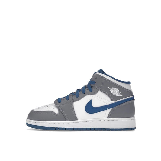 Jordan 1 Mid GS sneakers, side view, in true blue with cement grey and white accents.