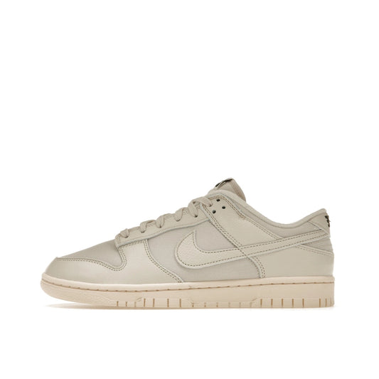 Nike Dunk Low Premium sneakers, side view, model DZ2538-100, in light orewood brown with white and beige accents.