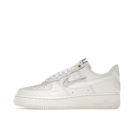 Nike Air Force 1 Low Premium, side view, in sail white with embossed Nike logo accents.