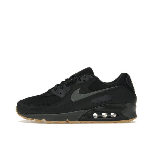 Nike Air Max 90, side view, in black and grey with reflective details and gum outsole.