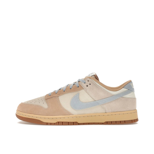 Nike Dunk Low Sanddrift sneakers, side view, model HF0106-100, in light armory blue with sanddrift and white accents.