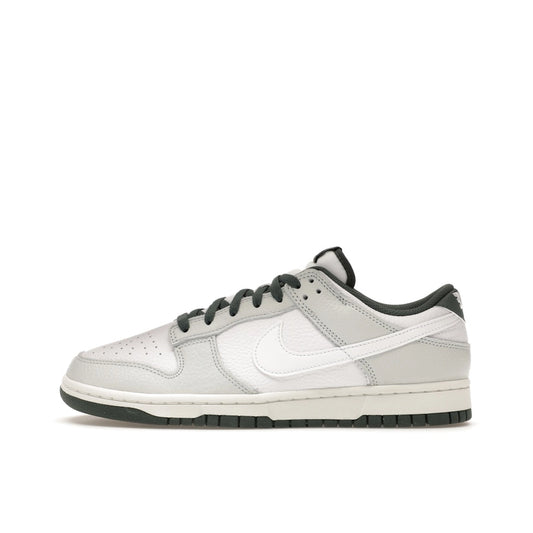 Nike Dunk Low Retro SE, side view, in photon dust and vintage green with aged midsole.