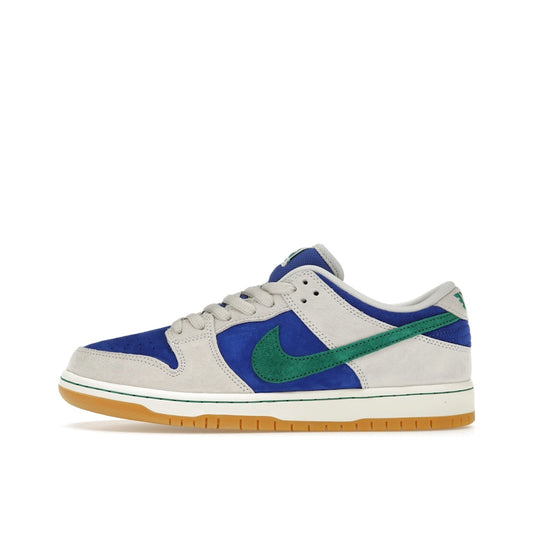Nike SB Dunk Low sneakers, side view, in black with bright blue and green contrast details.