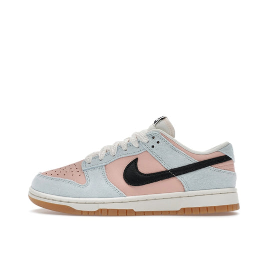 Nike Dunk Low Women’s sneakers, side view, in glacier blue with arctic orange accents.