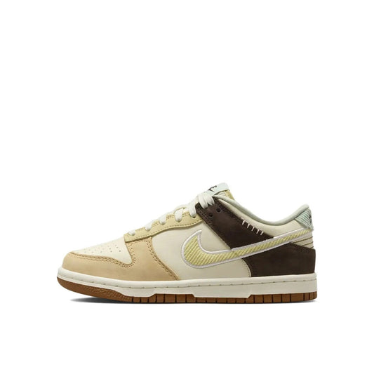 Nike Dunk Low GS sneakers, side view, in coconut milk and sail tones.