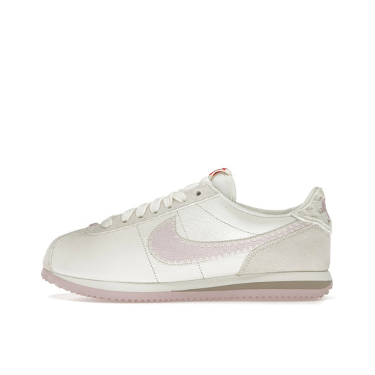 Nike Cortez Valentine’s Day 2025, side view, in white and soft red with heart details.