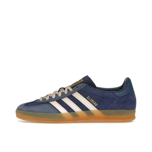 adidas Gazelle Indoor, side view, in dark blue suede with orange accents and retro silhouette.