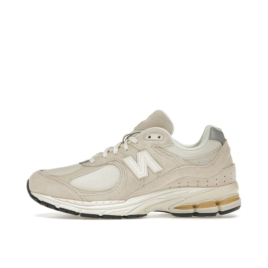 New Balance 2002R sneakers, side view, model M2002RCC, in off-white with subtle detailing.