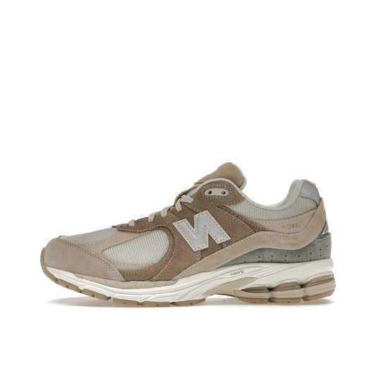New Balance 2002R Driftwood Sandstone sneakers, side view, in beige and tan tones.