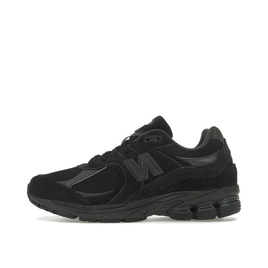 New Balance 2002R sneakers, side view, in triple black suede with tonal sole.