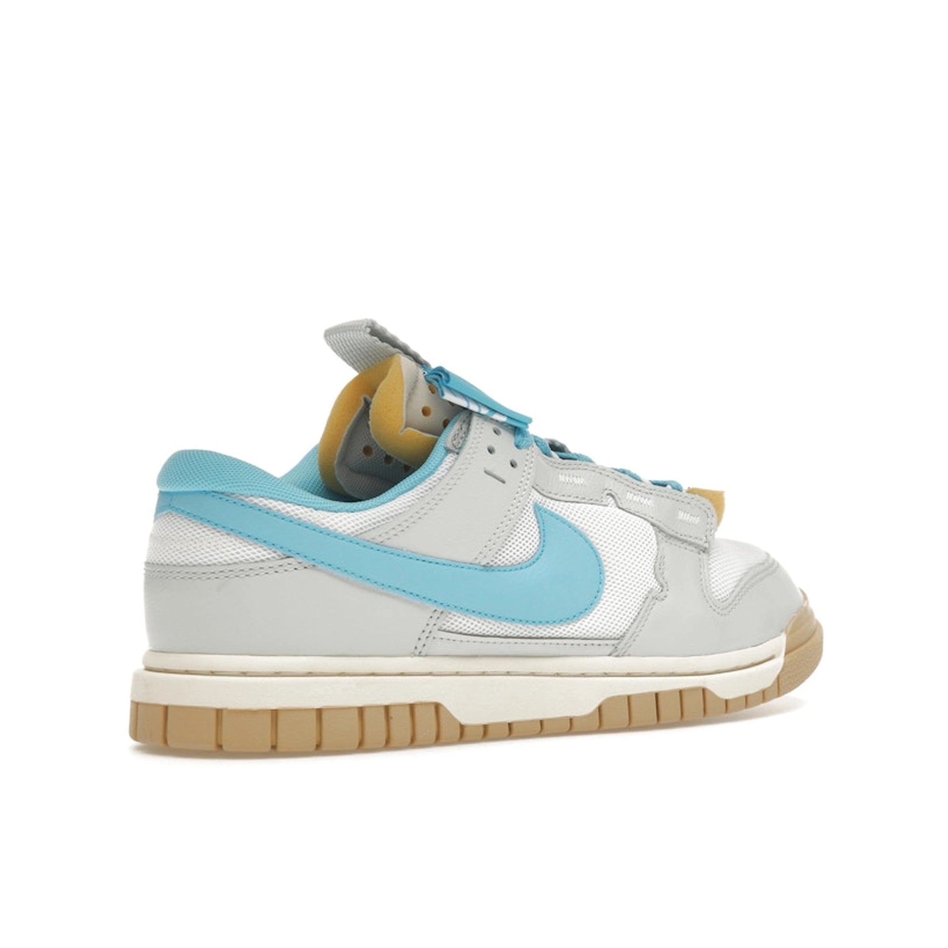 Nike Dunk Low Jumbo Photon Dust, back view, with oversized Baltic Blue Swoosh and grey upper.