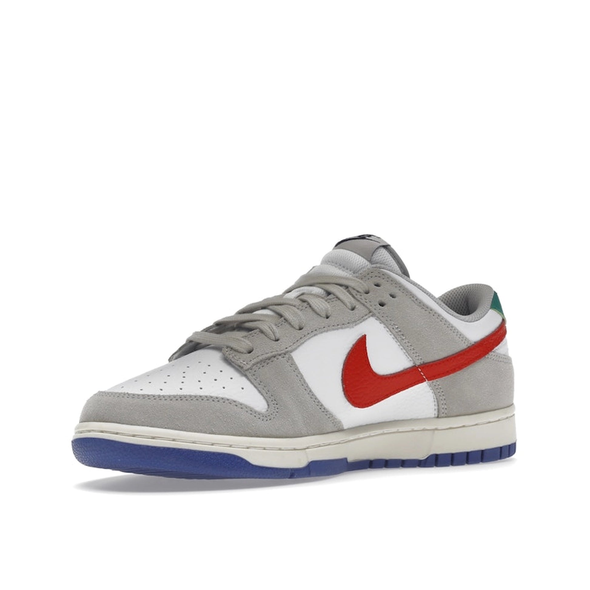 Nike Dunk Low sneakers, front view, model DV3497-001 in light iron ore with red and blue details.