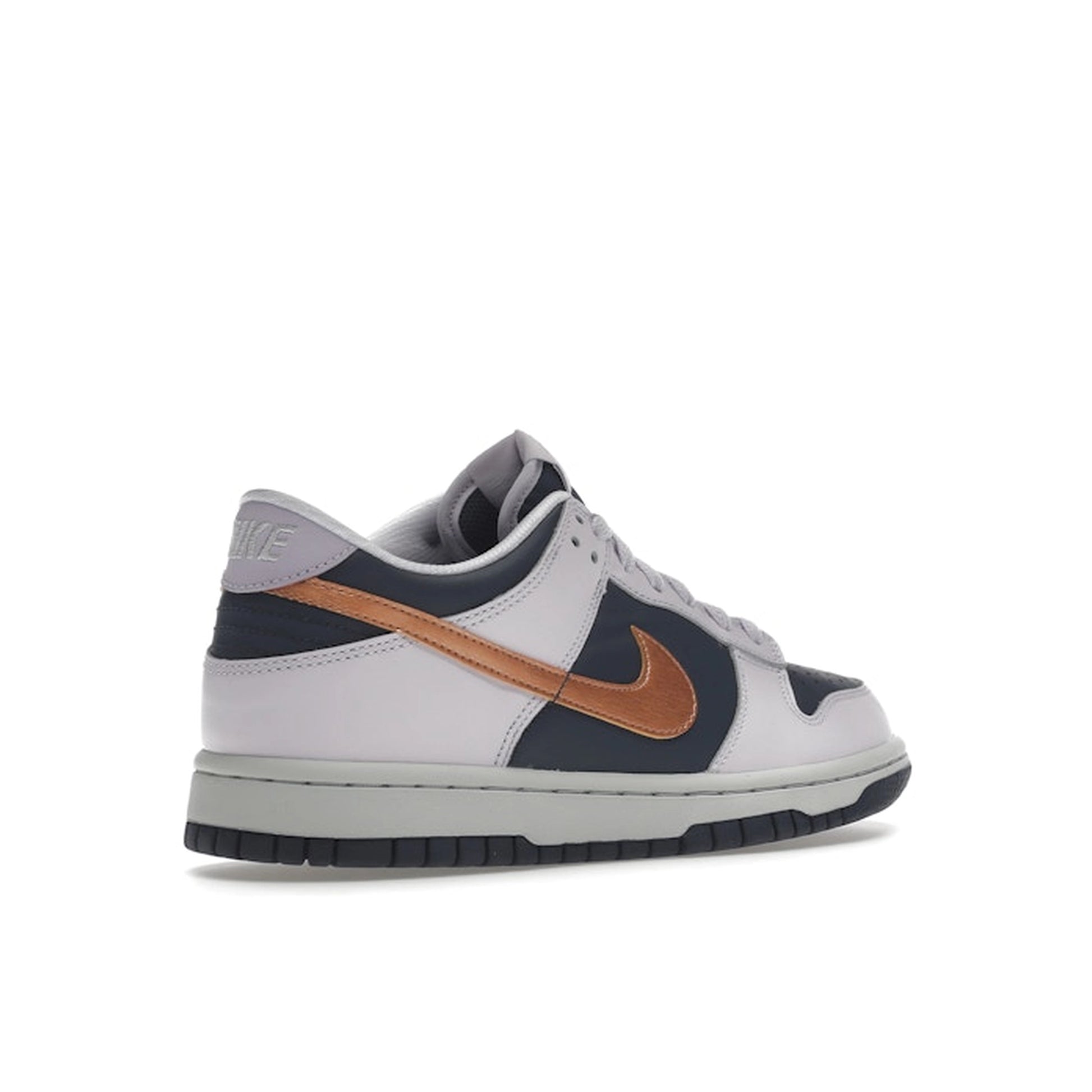 Nike Dunk Low SE GS sneakers, back view, in navy blue with metallic copper swoosh.