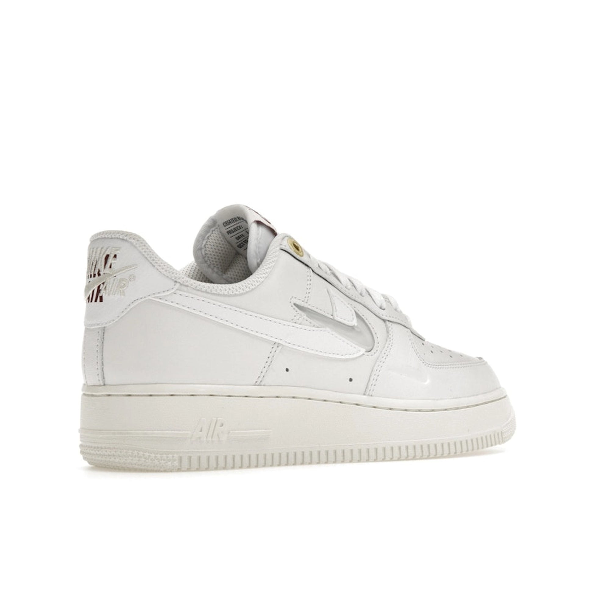 Nike Air Force 1 Low Premium, back view, in sail white with embossed Nike logo accents.