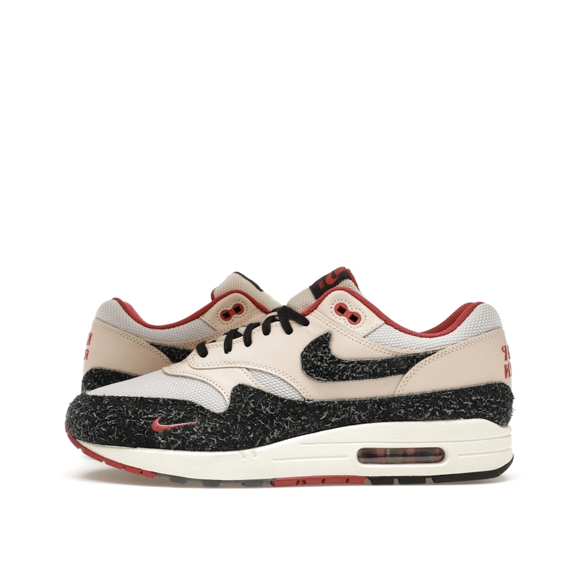 Nike Air Max 1 Keep Rippin Stop Slippin 2.0 sneakers, side view, model FD5743-200, black and beige with red accents.