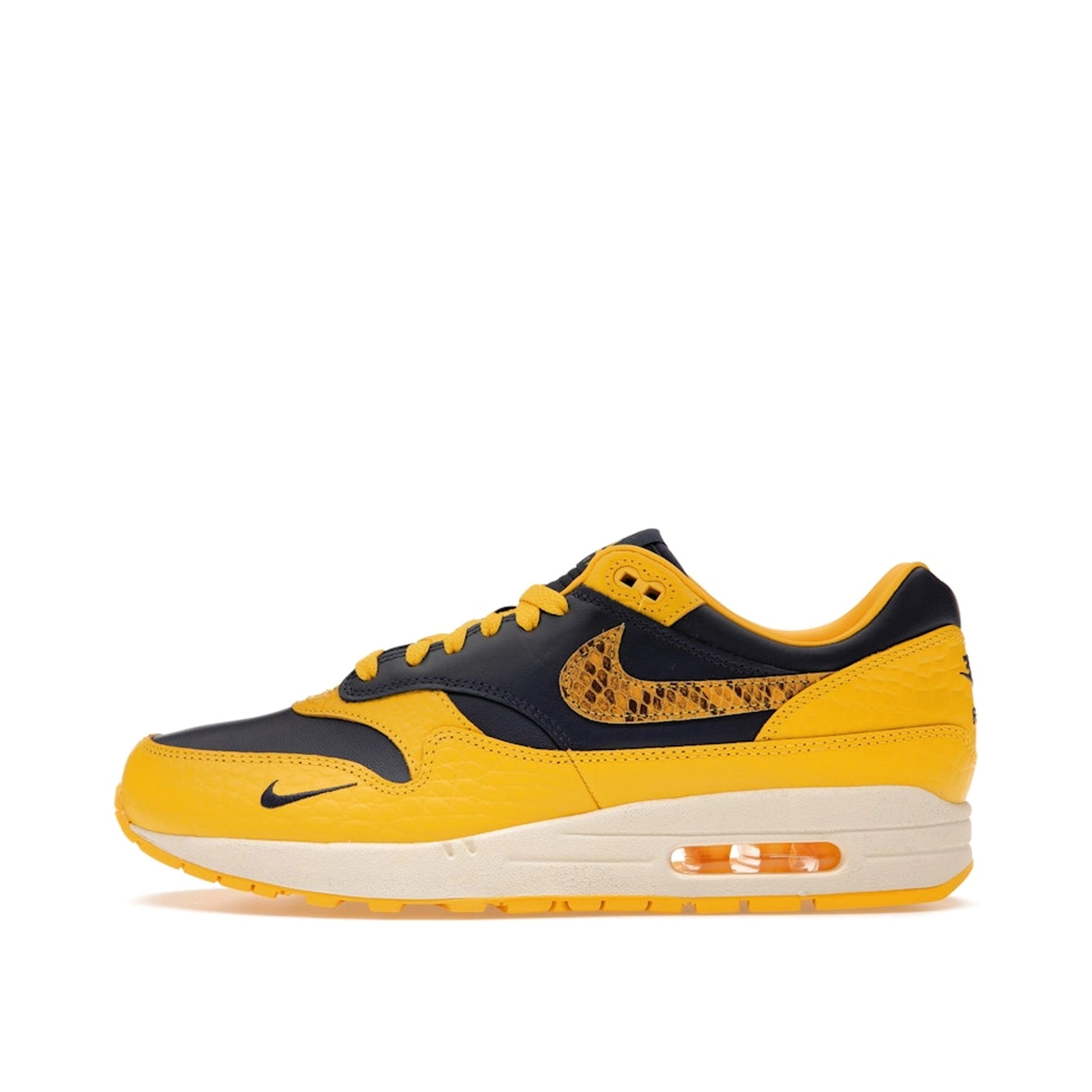 Nike Air Max 1 CO.JP Michigan Women’s sneakers, side view, in navy blue and maize yellow.