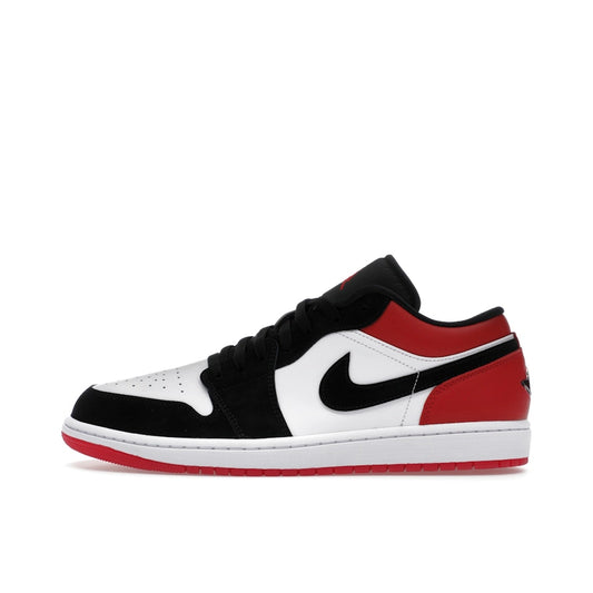 Jordan 1 Low SE Black Toe (2025), side view, in white leather with black toe box and red heel.